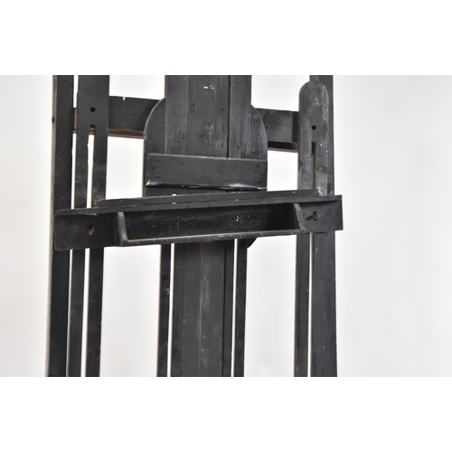 99 - A large Victorian 19th century black painted wood studio artist's easel. The easel raised on brass c... 