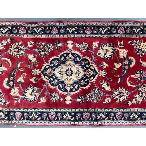 71 - A 20th century Central Persian Islamic Kashan floor carpet runner rug. The rug in a silk red ground ... 