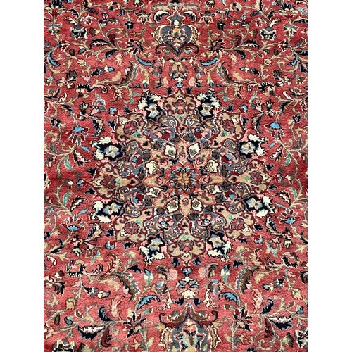 168 - A 20th century Persian Islamic Abousson style floor carpet rug. The rug on a pink wool background de... 