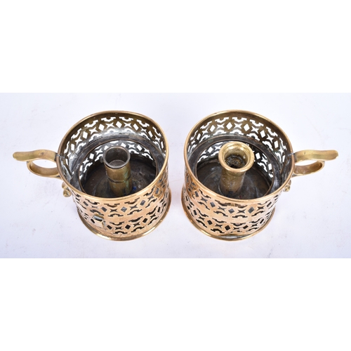 324 - A pair of mid-late 19th century brass candle stick holders / nightlights. Each with finger ring and ... 