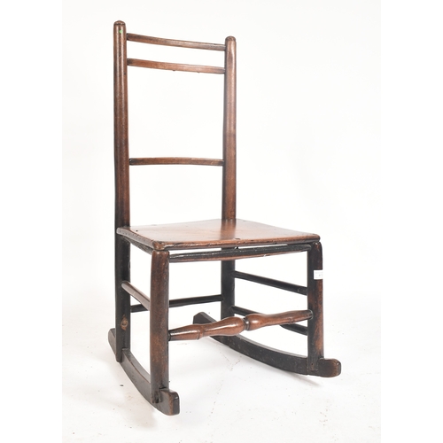 413 - A Victorian 19th century elm child's rocking chair. The chair having a ladder back with turned side ... 