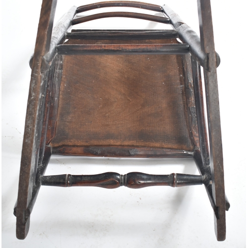 413 - A Victorian 19th century elm child's rocking chair. The chair having a ladder back with turned side ... 