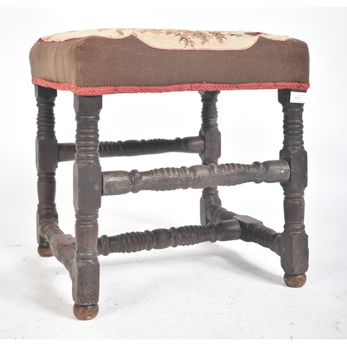 427 - An 18th century English oak and tapestry upholstered stool. The stool with tapestry overstuffed seat... 