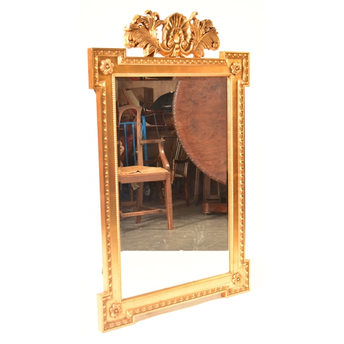 595 - A 20th century Regency Adams revival gilt framed wall  mirror. The dog ear shaped overmantel mirror ... 