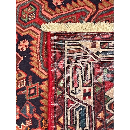 274 - A 20th century Persian Islamic Belouch floor carpet runner rug. The rug having a series of three geo... 