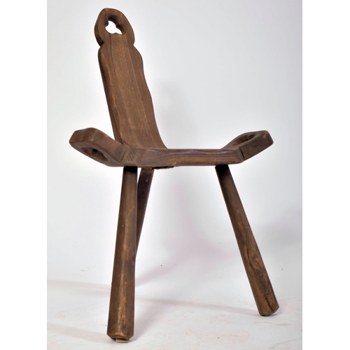 303 - A late 19th century Brutalist elm wood birthing milking tripod stool / chair. The stool having a han... 