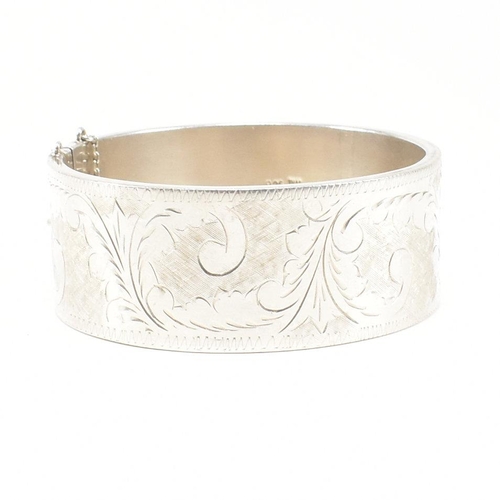 113 - A 925 silver hinged bangle. The bangle having etched foliate decoration to concealed box clasp. Mark... 