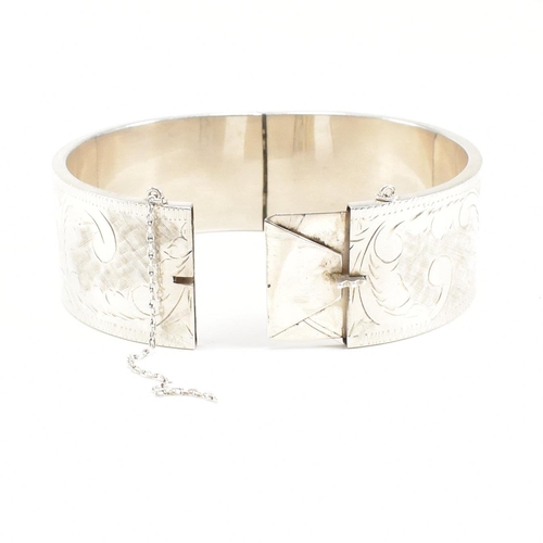 113 - A 925 silver hinged bangle. The bangle having etched foliate decoration to concealed box clasp. Mark... 