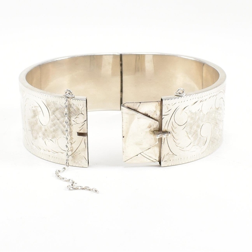 113 - A 925 silver hinged bangle. The bangle having etched foliate decoration to concealed box clasp. Mark... 