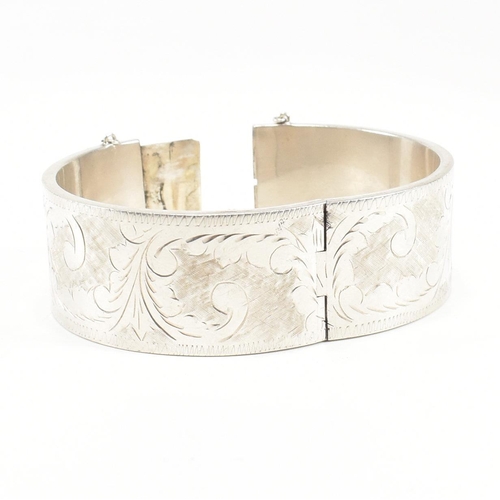 113 - A 925 silver hinged bangle. The bangle having etched foliate decoration to concealed box clasp. Mark... 