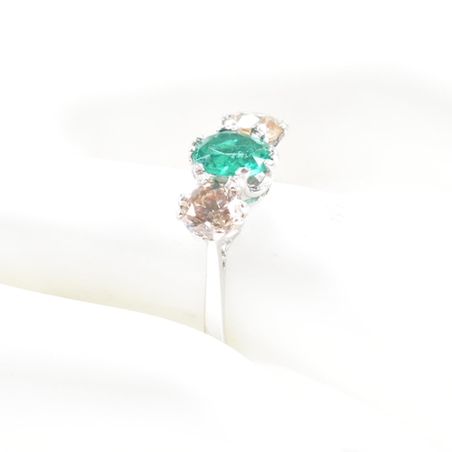 124 - A 18ct white gold emerald and diamond three stone ring. Weight approx 3.6g. Size approx M. Diamonds ... 