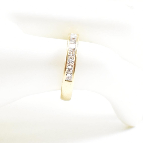 125 - A hallmarked 18ct gold and diamond half eternity ring. The ring set with 9 princess cut diamonds. Es... 