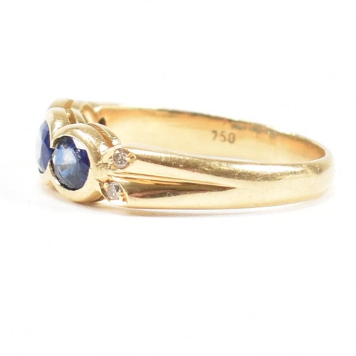 13 - An 18ct gold sapphire and diamond three stone ring. The ring set with three oval cut sapphires havin... 