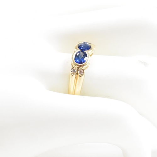 13 - An 18ct gold sapphire and diamond three stone ring. The ring set with three oval cut sapphires havin... 