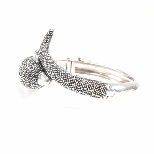 133 - A contemporary white metal and marcasite novelty dolphin bangle having ruby set eyes. Weight approx ... 