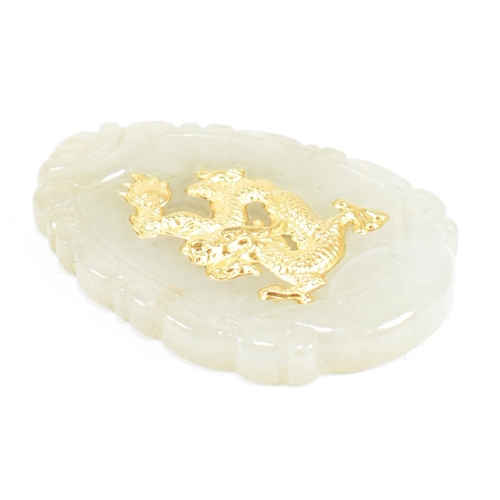 160 - A Chinese jade necklace pendant. The pendant having a gilded Qilin motif to the center of a scrolled... 