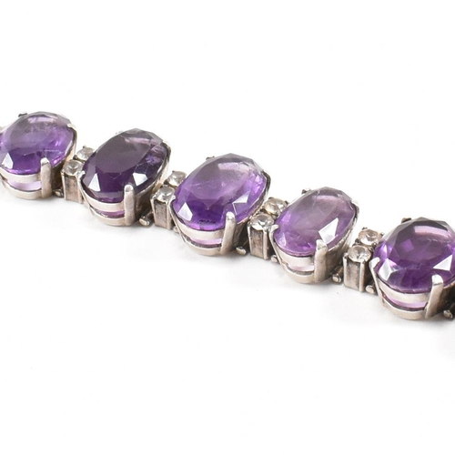 173 - An silver and amethyst bracelet . The bracelet having graduated oval cut amethyst with white topaz a... 