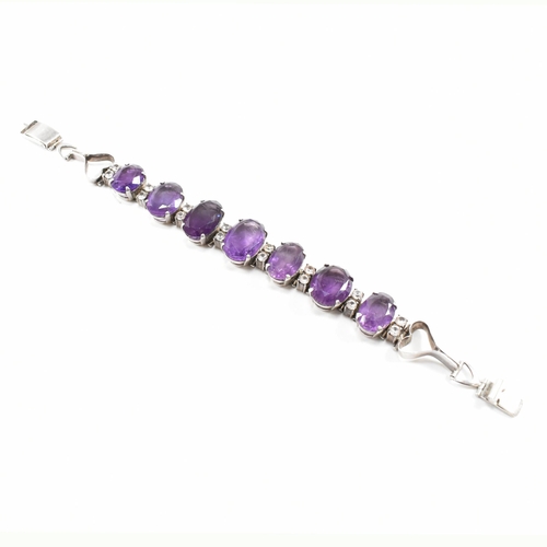 173 - An silver and amethyst bracelet . The bracelet having graduated oval cut amethyst with white topaz a... 