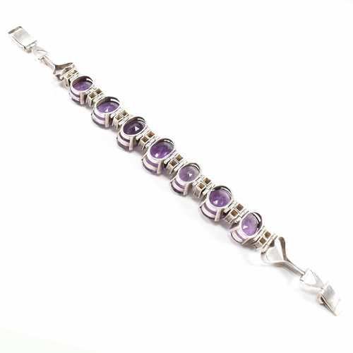 173 - An silver and amethyst bracelet . The bracelet having graduated oval cut amethyst with white topaz a... 