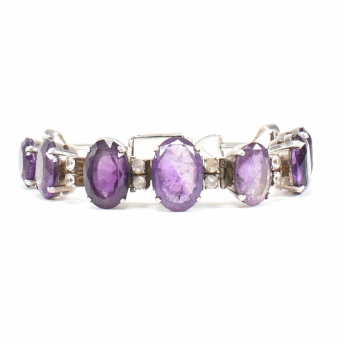 173 - An silver and amethyst bracelet . The bracelet having graduated oval cut amethyst with white topaz a... 