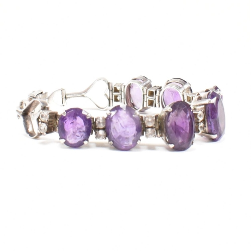 173 - An silver and amethyst bracelet . The bracelet having graduated oval cut amethyst with white topaz a... 