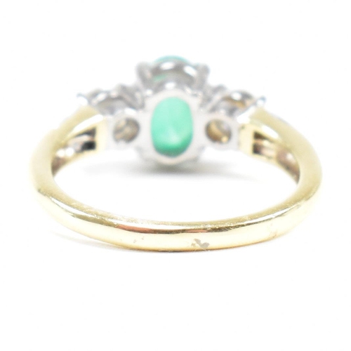 2 - A hallmarked 18ct gold emerald and diamond three stone ring. The ring set with a central emerald ova... 