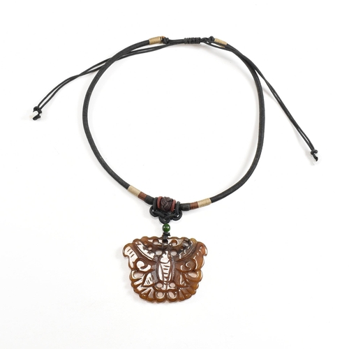 206 - Two carved Chinese hardstone necklaces. A necklace strung with a carved brown jade moth surmounted b... 