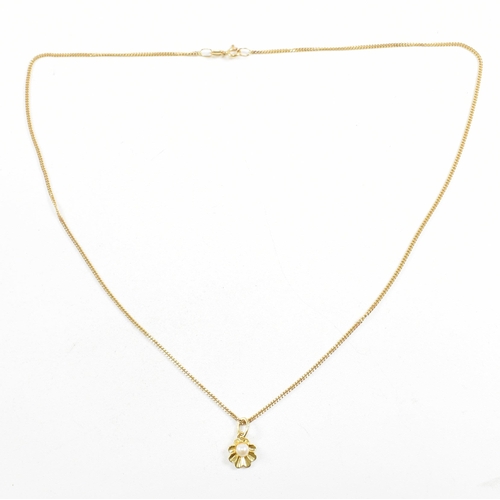 209 - A hallmarked 9ct gold and pearl pendant necklace. The necklace strung with a flower pendant set with... 