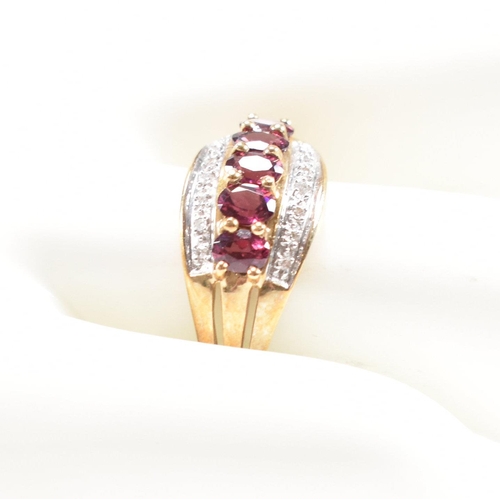 212 - A 9ct gold garnet and diamond dress ring having pierced shoulders and tapering shank. Weight 2.6g. S... 