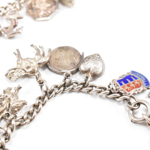 230 - Two silver and white metal charm bracelets adorned with multiple charms to include moon, Welsh drago... 