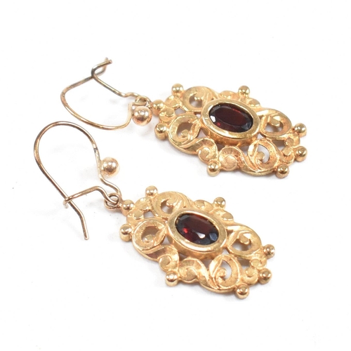 262 - A pair of hallmarked 9ct gold pendant earrings. A pair of earrings set with an oval cut garnet and a... 