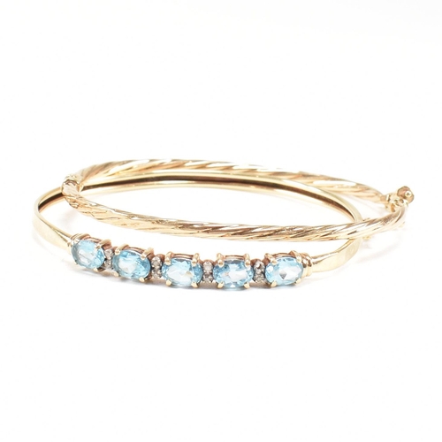 265 - Two 9ct gold bangles. A topaz set bangle and a rope twist style bangle. Both with dents and one ston... 