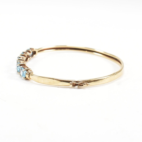 265 - Two 9ct gold bangles. A topaz set bangle and a rope twist style bangle. Both with dents and one ston... 