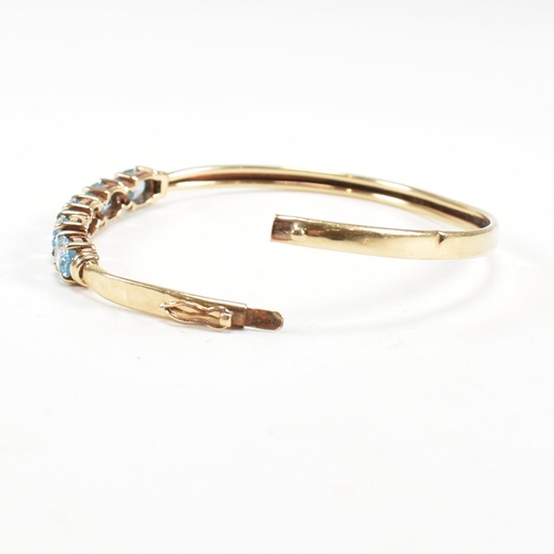 265 - Two 9ct gold bangles. A topaz set bangle and a rope twist style bangle. Both with dents and one ston... 