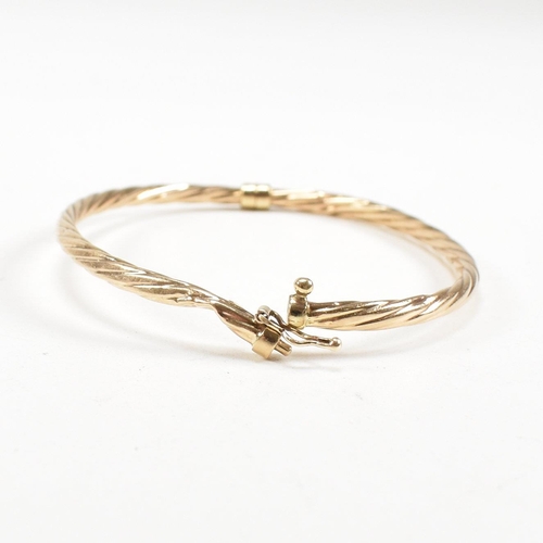 265 - Two 9ct gold bangles. A topaz set bangle and a rope twist style bangle. Both with dents and one ston... 