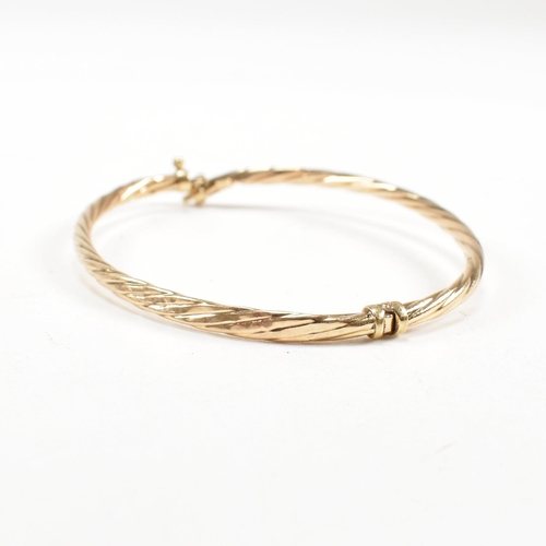 265 - Two 9ct gold bangles. A topaz set bangle and a rope twist style bangle. Both with dents and one ston... 