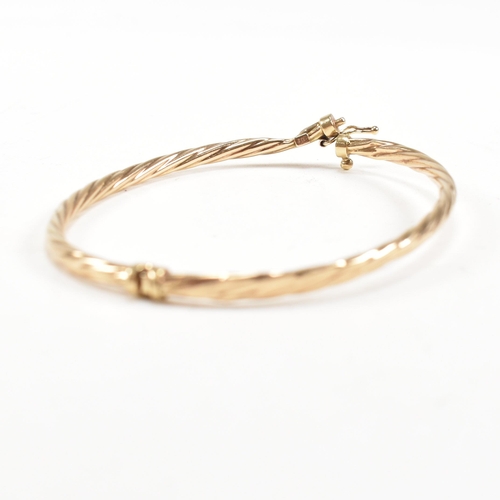 265 - Two 9ct gold bangles. A topaz set bangle and a rope twist style bangle. Both with dents and one ston... 