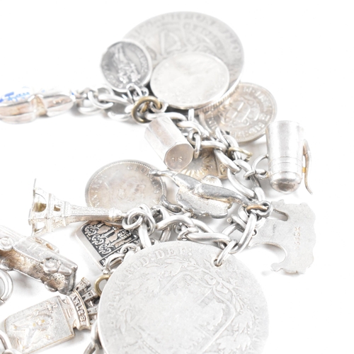 273 - A  silver and white metal charm bracelet AF. The bracelet strung with multiple charms including Vict... 