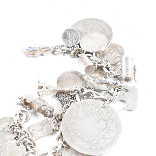 273 - A  silver and white metal charm bracelet AF. The bracelet strung with multiple charms including Vict... 