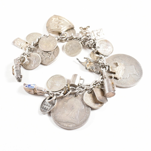 273 - A  silver and white metal charm bracelet AF. The bracelet strung with multiple charms including Vict... 