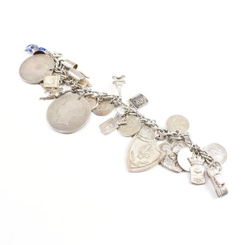 273 - A  silver and white metal charm bracelet AF. The bracelet strung with multiple charms including Vict... 