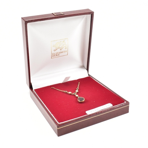 285 - A hallmarked 9ct gold garnet and pearl pendant necklace.  Weight 2.7g. Measures 40cm plus pendant 2.... 