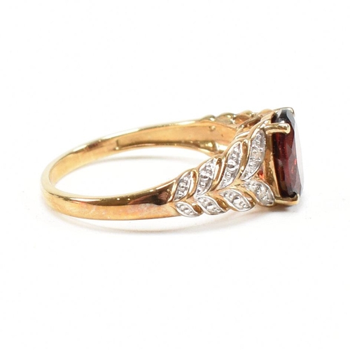 296 - A hallmarked 9ct gold and garnet ring. The ring set with an oval cut garnet to diamond set pierced f... 