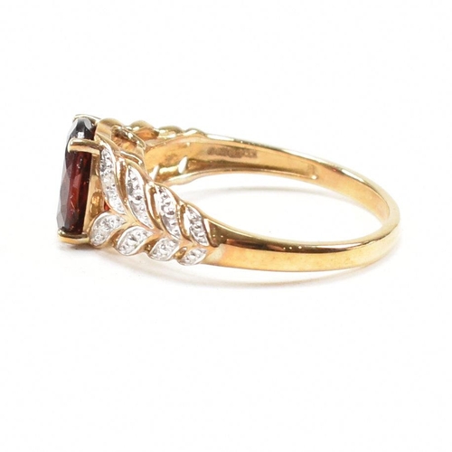 296 - A hallmarked 9ct gold and garnet ring. The ring set with an oval cut garnet to diamond set pierced f... 