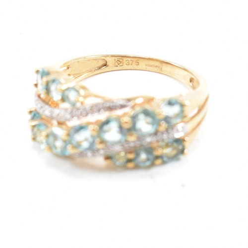 32 - A hallmarked 9ct gold aquamarine and diamond crossover ring. Weight 3.4g. Size O. All weights, measu... 