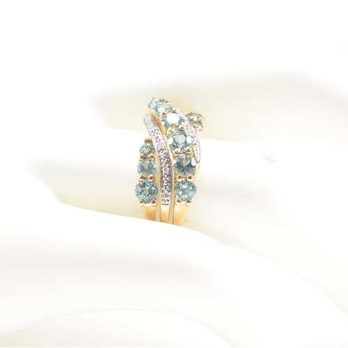 32 - A hallmarked 9ct gold aquamarine and diamond crossover ring. Weight 3.4g. Size O. All weights, measu... 