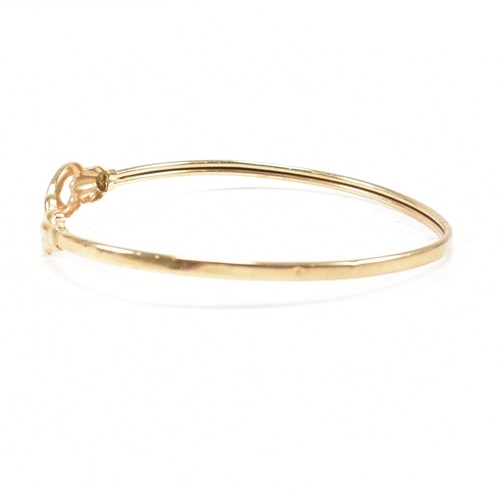 337 - A gold torque bangle. The bangle having heart finials with tube band. Marked 375. tests indicate 9ct... 