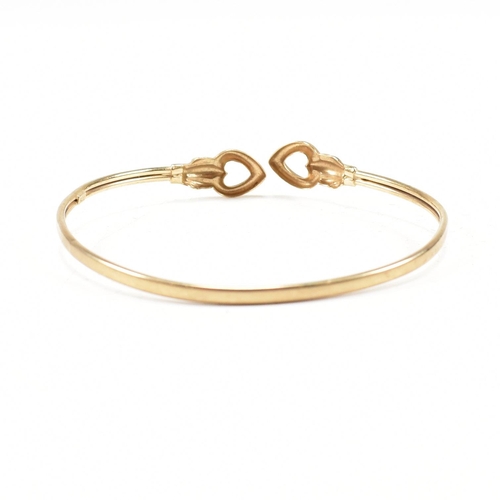 337 - A gold torque bangle. The bangle having heart finials with tube band. Marked 375. tests indicate 9ct... 