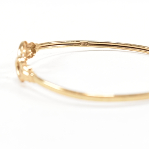 337 - A gold torque bangle. The bangle having heart finials with tube band. Marked 375. tests indicate 9ct... 