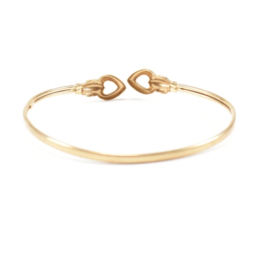 337 - A gold torque bangle. The bangle having heart finials with tube band. Marked 375. tests indicate 9ct... 